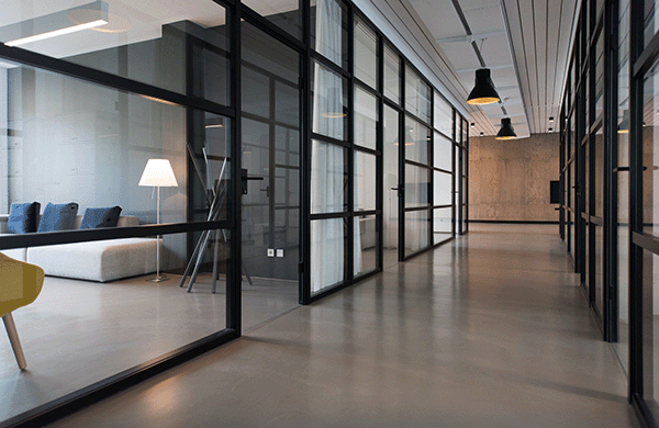 A clean and inviting commercial real estate hallway with offices on the sides.